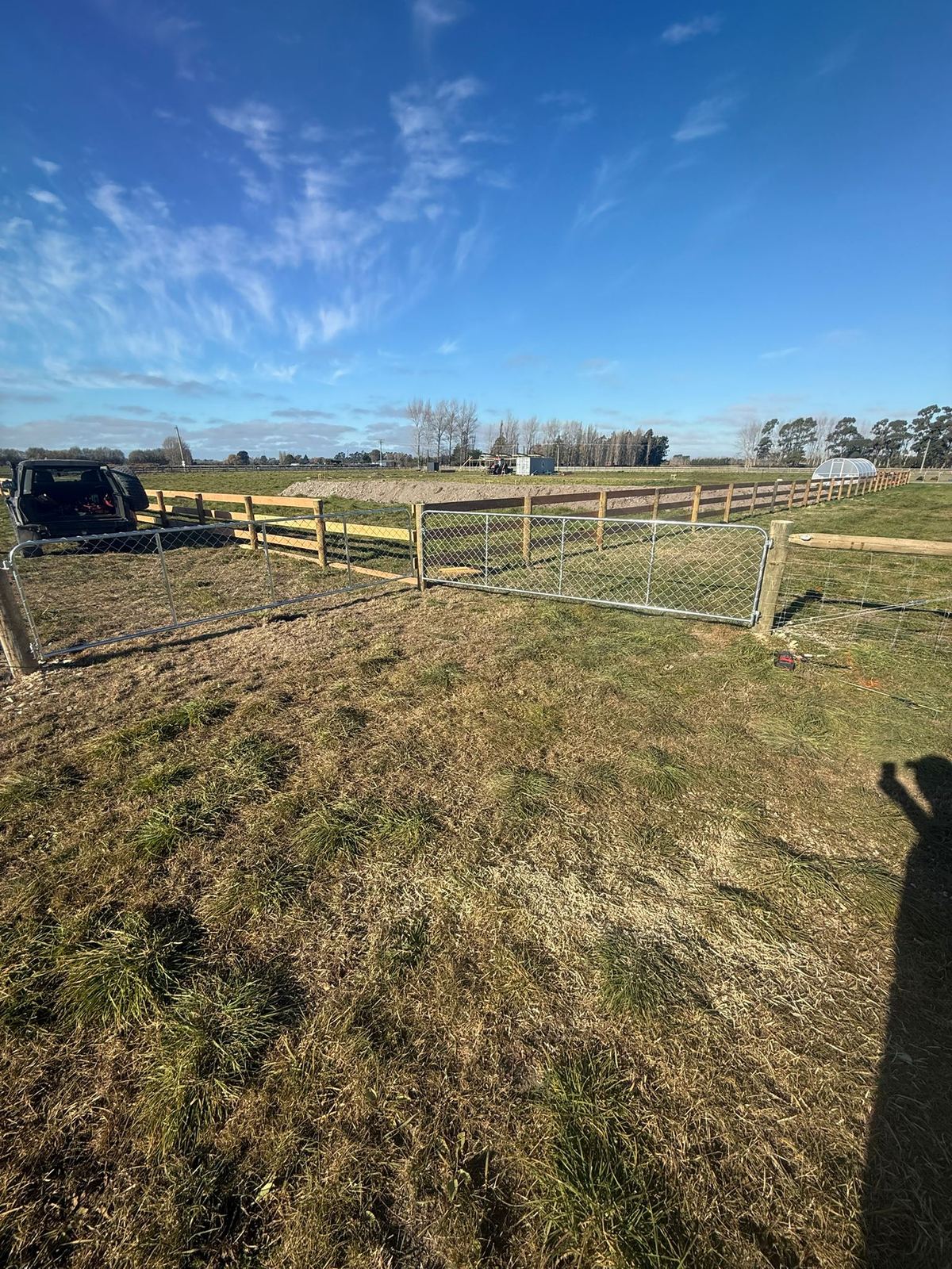 A timber farm gate hung on a new fence line