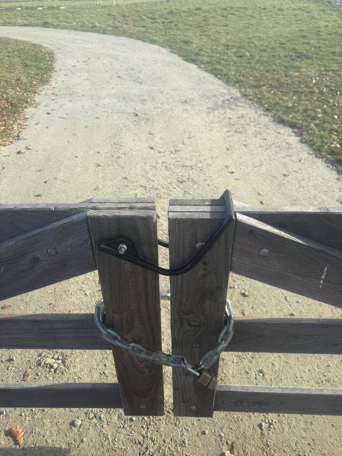 A close view of the latch on a newly hung farm gate
